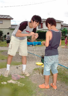 ボランティアで子どもに遊びを教える中学生の写真