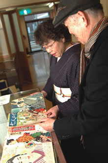当時の雑誌に見入る石上さんの写真