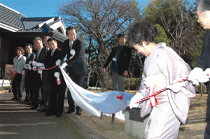 歌碑の除幕をする石上さん、本郷谷市長らの写真