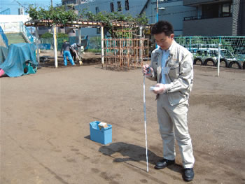 簡易測定器で市内の公園の放射線量を測定する市の職員の写真