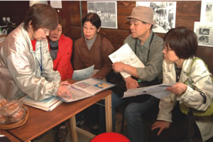 来店者に松戸の見どころを説明する石上さんの写真
