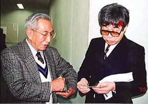 崎本平一郎さん(左)と立川談志さんの写真